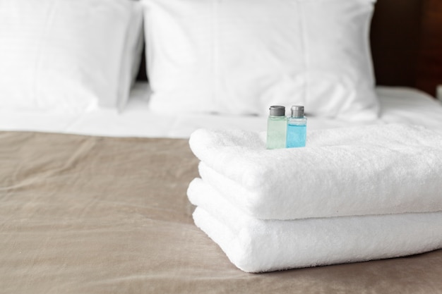 Foto toalla blanca en cama en habitación de huéspedes para cliente del hotel.
