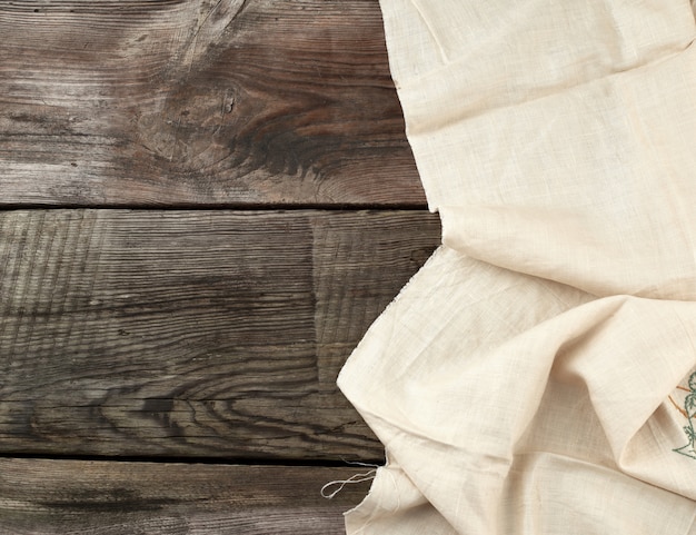 Toalla blanca de cocina doblada sobre una mesa de madera gris