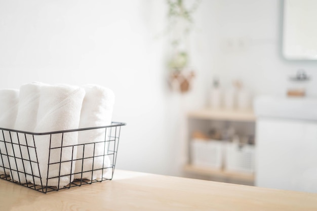 Toalla blanca de spa enrollada en una canasta metálica higiene cómoda textil fresco baño borroso