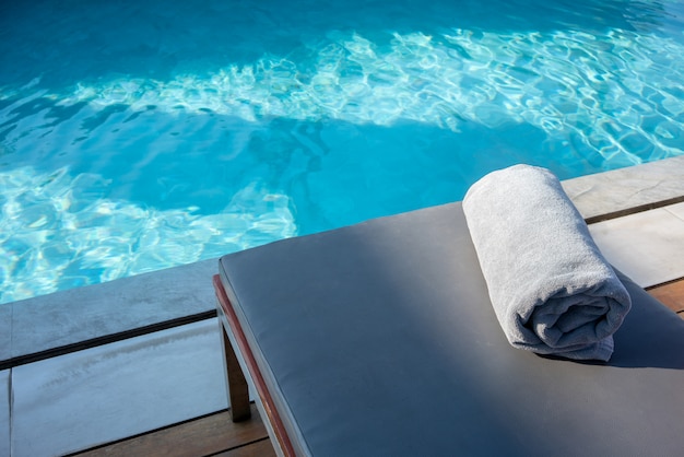 Foto toalla en la cama de la piscina relajante al lado de la piscina.