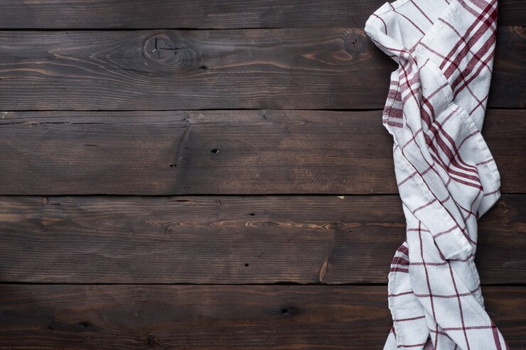 Toalla de cocina servilleta textil. Fondo de mesa rústica de madera. Copia espacio