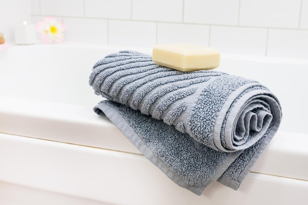 Toalla gris y barra de jabón en la bañera blanca SPA y relajarse en casa Horizontal