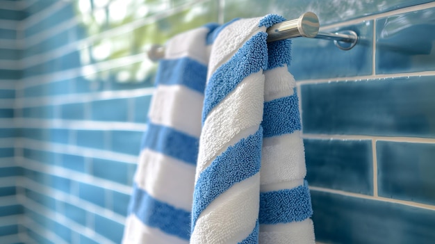 Foto toalla de rayas azules y blancas colgada en un carril de baño