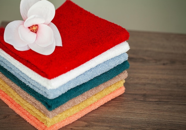 Toallas de algodón de colores en el baño en la mesa de madera blanca