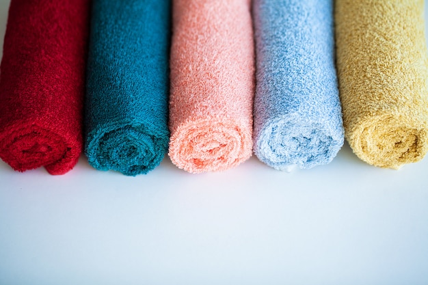 Toallas de colores en la mesa blanca con espacio de copia en el baño