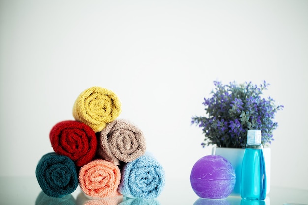 Toallas de colores sobre una mesa blanca con espacio para copiar en el fondo del baño.