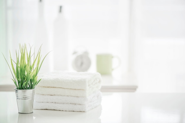 Toallas en la mesa blanca con espacio de copia en el fondo de baño borrosa