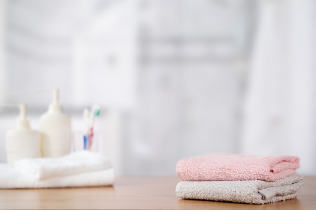 Toallas en la mesa de madera con espacio de copia en baño borroso.