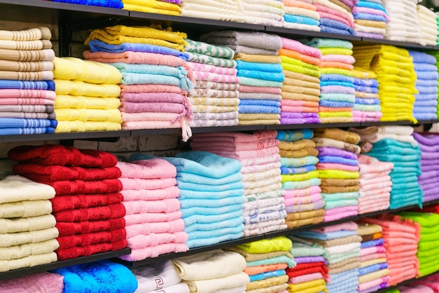 Toallas multicolores en el estante en el mercado venta de toallas de algodón pila de algodón de colores