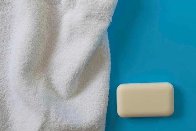 Toallas suaves y esponjosas sobre un fondo azul Jabón para la ropa de baño y el cuidado del cuerpo Productos de higiene personal Accesorios de baño