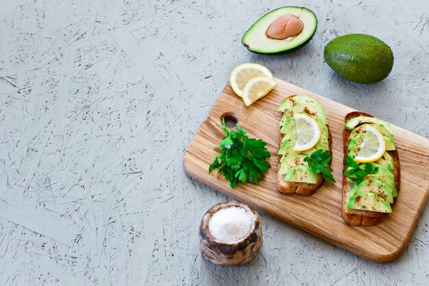 Toast mit Avocado, Zitrone, Paprika oder Paprika auf grauem Hintergrund