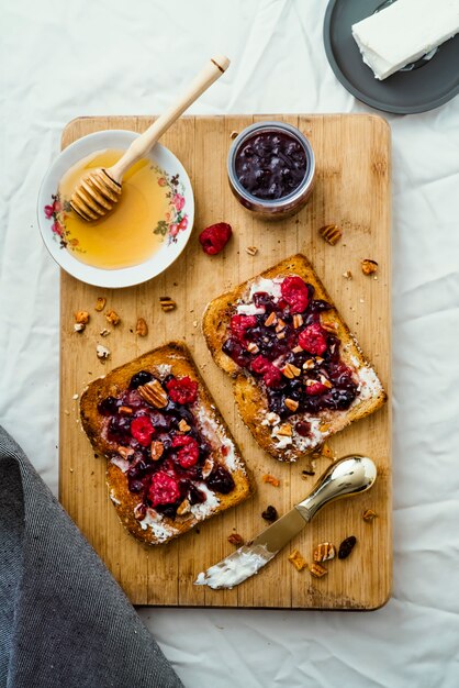 Toast mit Honig, Frischkäse und Marmelade aus roten Beeren