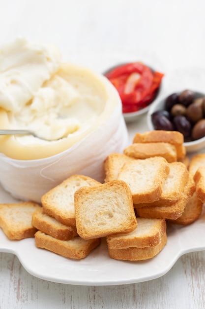 Toast mit käse, oliven und rotem pfeffer auf weißem teller