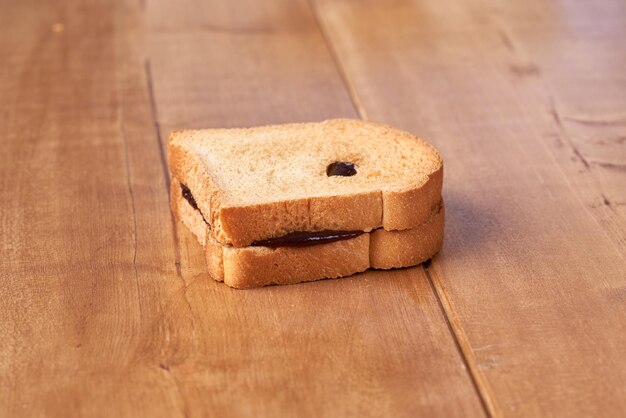 Toast mit Pflaumenmarmelade auf dem Holztisch.