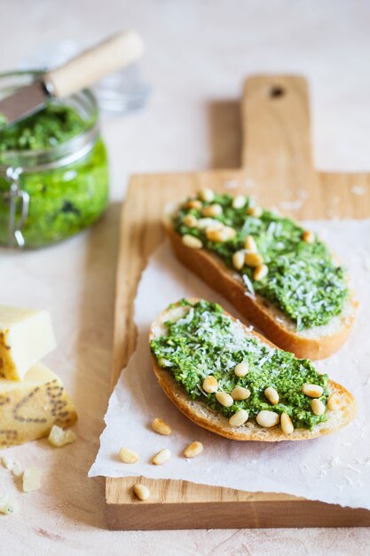 Toast mit traditioneller italienischer Basilikum-Pesto-Sauce auf einem hellgrauen Steintisch