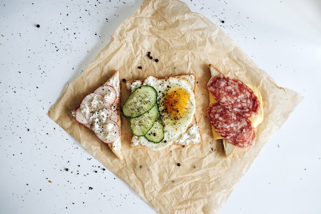 Toast mit verschiedenen Geschmacksrichtungen liegen auf Pergament. Schönes konzeptionelles Foto des Röstens von oben