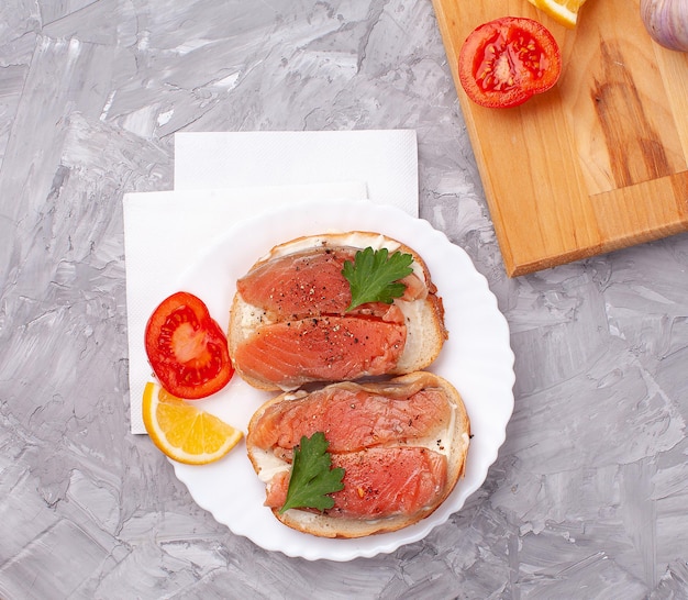 Foto toast-sandwiches mit tomaten und lachs auf betonhintergrund