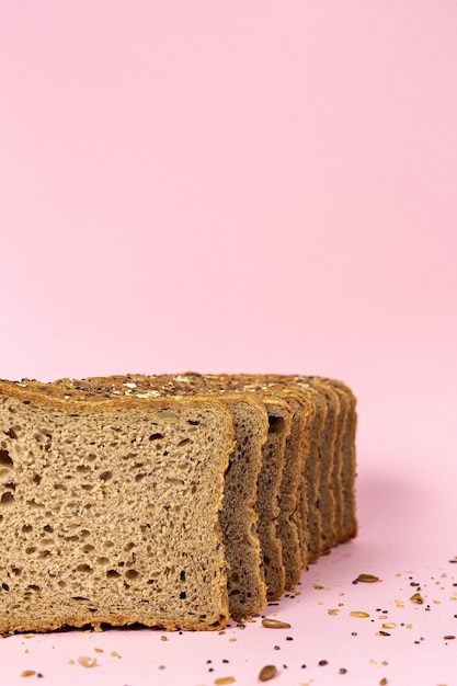 Toast-Weizenbrot in Scheiben geschnitten mit Getreide auf Farbhintergrund isoliert.