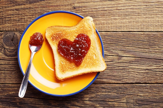 Toastbrot mit Marmelade in Form von Herzen auf dem Tisch