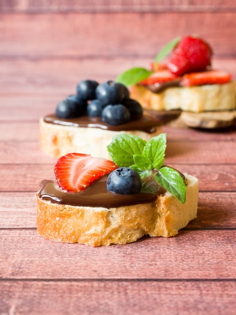 Toastbrot mit Schokoladenpaste und Erdbeerblaubeerminze auf dem Tisch