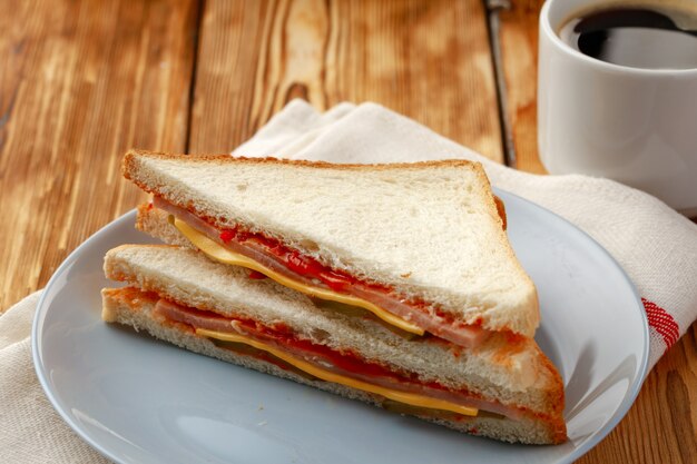 Toastsandwich und Tasse Kaffee auf Serviette auf Holztisch