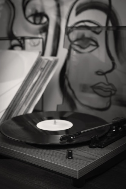 Tocadiscos elegante con disco de vinilo en la mesa en el primer plano de la habitación Filtro blanco negro