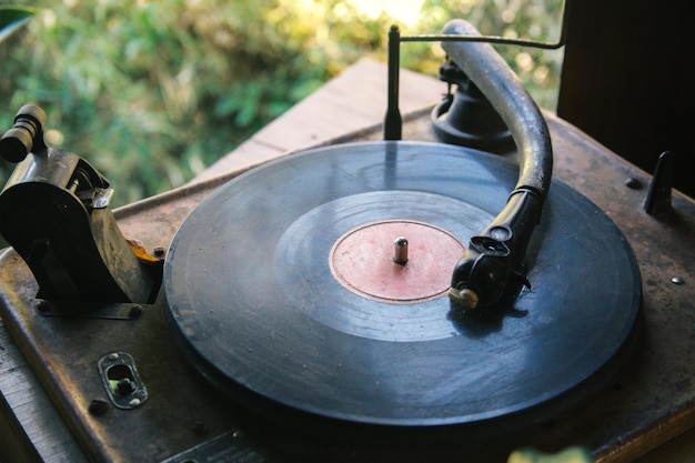 Tocadiscos de fonógrafo de gramófono envejecido antiguo vintage sobre mesa de madera