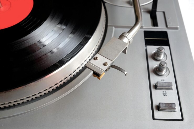 Foto tocadiscos de la vieja escuela en estuche plateado con disco de vinilo con etiqueta roja vista superior aislada