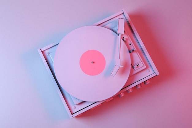 Tocadiscos de vinilo blanco en luz degradada de neón azul rosa Concepto de música minimalista Vista superior