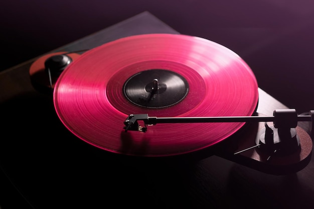 Tocadiscos de vinilo para DJ en iluminación de club. de cerca. tinte rosa. estilo retro