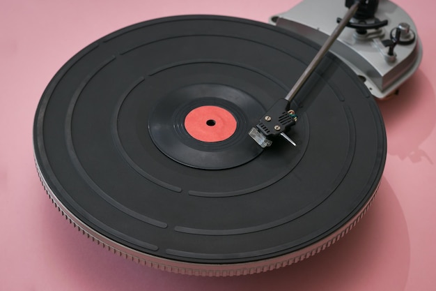 Tocadiscos de vinilo vintage sobre un fondo rosa. Técnica retro para tocar música.