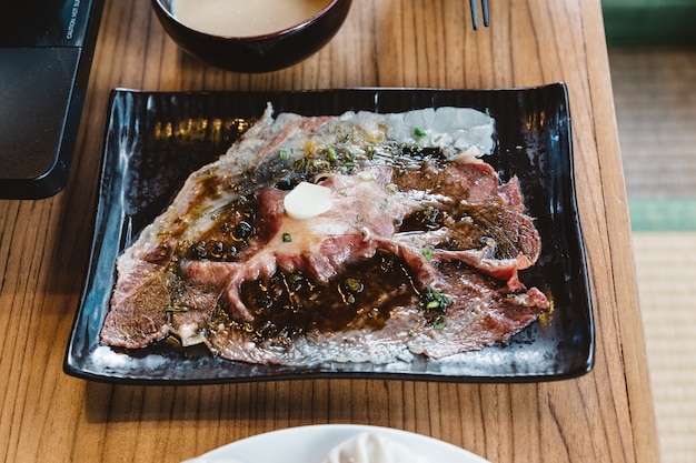 Tocado medio raro en rodajas auténtico Wagyu carne japonesa sushi cubierta con ajo fresco.