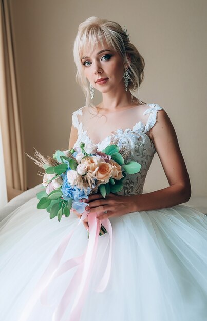 Tocador de la novia. Encantadora novia por la mañana en una bata se prepara para la celebración