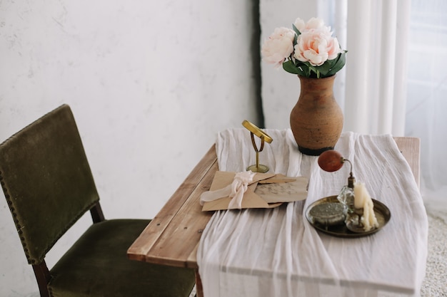 Foto tocador romántico con un ramo de peonías en un jarrón y un espejo.