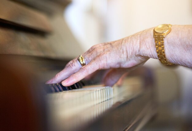 Tocando uno de sus viejos favoritos Foto de una anciana no identificable tocando el piano en casa