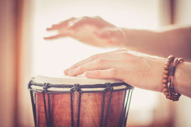 Tocando tambor cortado de mãos masculinas que estão tocando no ritmo