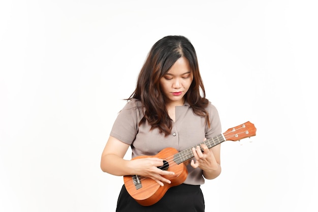 Tocando Ukulele de linda mulher asiática isolada no fundo branco