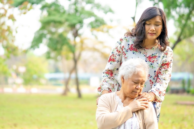 Tocante mãos paciente sênior mulher asiática com amor.