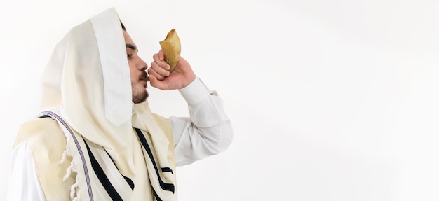 Tocar o homem do shofar em um xale de oração judaico talith é tocar a buzina do carneiro do shofar