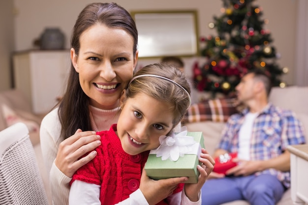 Tochter, die ein Geschenk mit ihrer Mutter hält