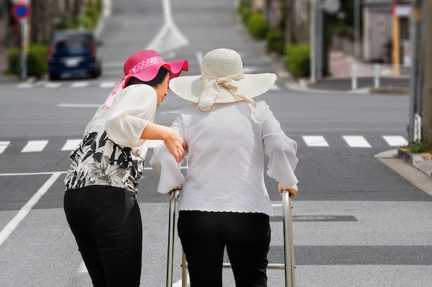 Tochter kümmert sich um ältere Frau, die auf der Straße in der Innenstadt spazieren geht