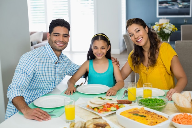 Tochter und Eltern essen zu Hause auf dem Tisch