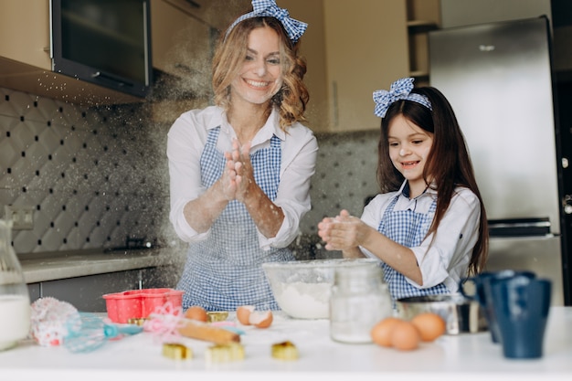 Tochter und Mutter beim Kochen und Backen klatschen in die Hände