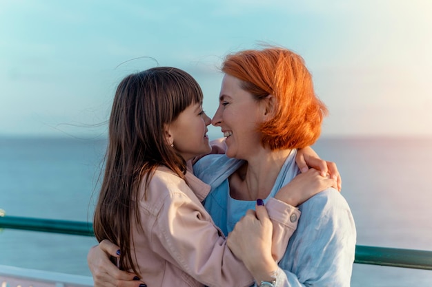 tochter und mutter haben spaß am strand bei sonnenuntergang