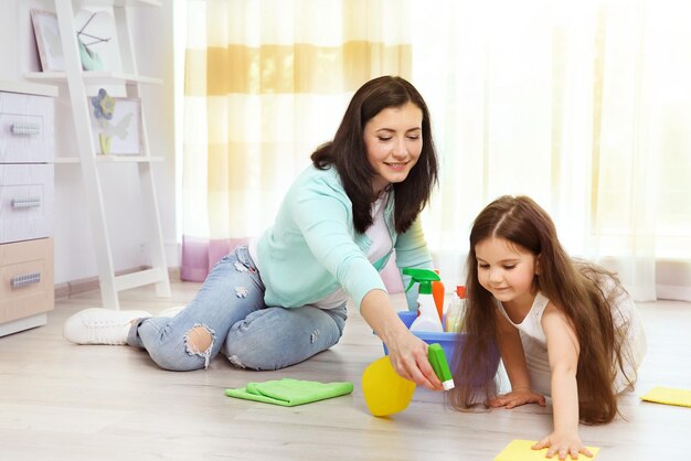 Tochter und Mutter waschen gemeinsam den Boden im Zimmer