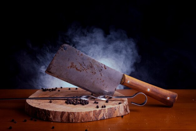 Tocino con carne con cuchillo en la tabla de cortar de madera con fondo negro