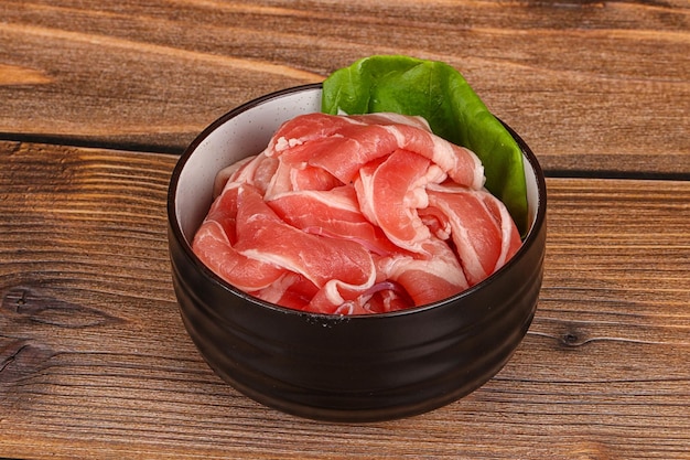 Tocino de cerdo en rodajas en el tazón