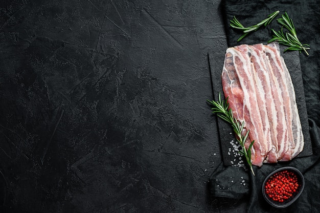 Tocino crudo en una tabla de cortar de piedra.