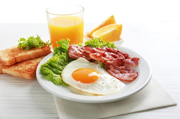 Tocino y huevos sobre fondo de mesa de madera de color