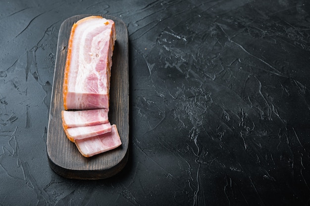 Foto tocino panceta cortado y rebanado en negro